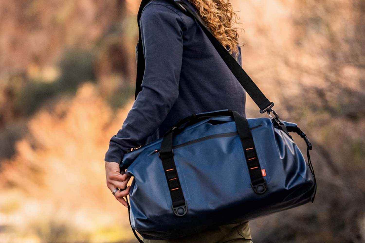 Man carrying a Wren dry bag outside