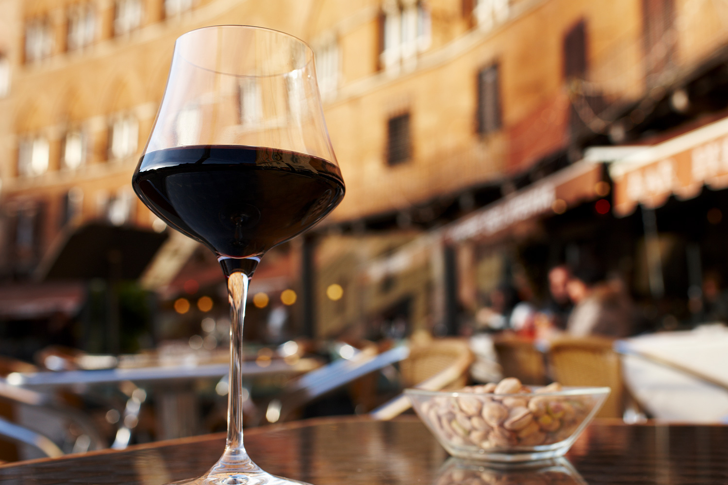 a glass of red wine on an outdoor table