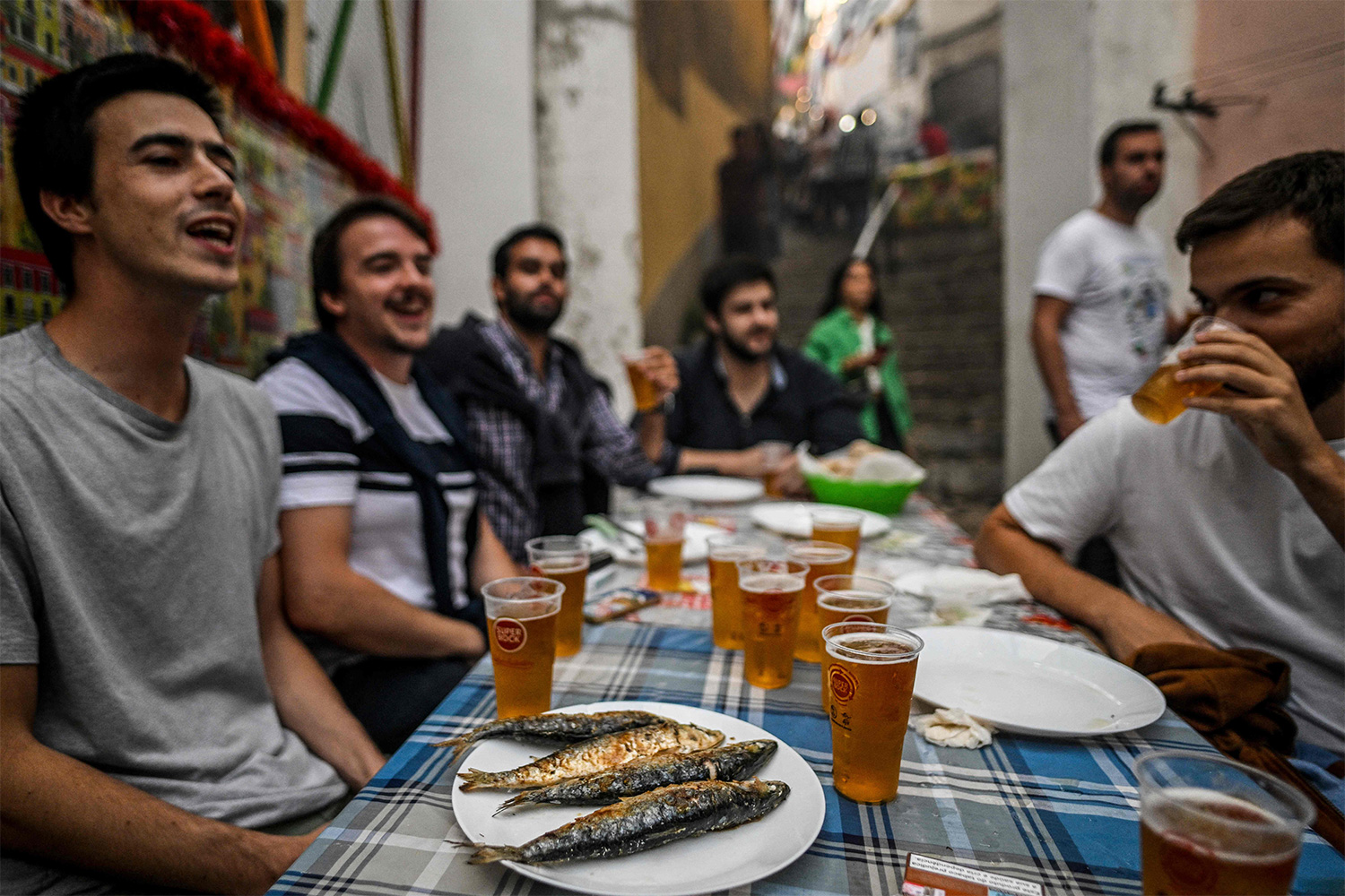 People eat sardines and drink during Lisbon's Saint Anthony celebration in Lisbon.