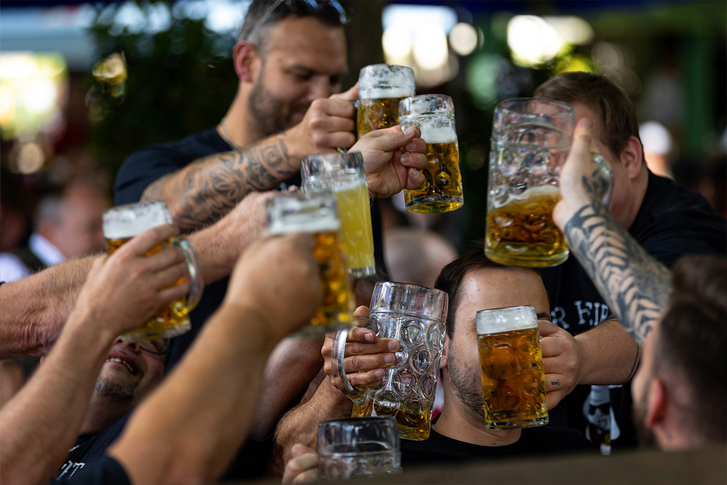 a bunch of men cheersing steins of beer