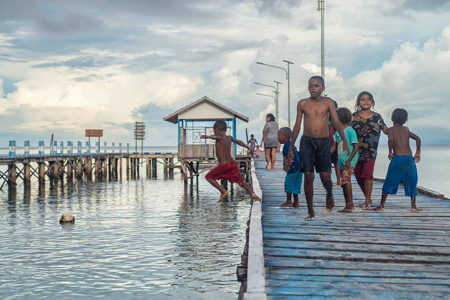 Local youngsters play on the jetty at Sawandarek village