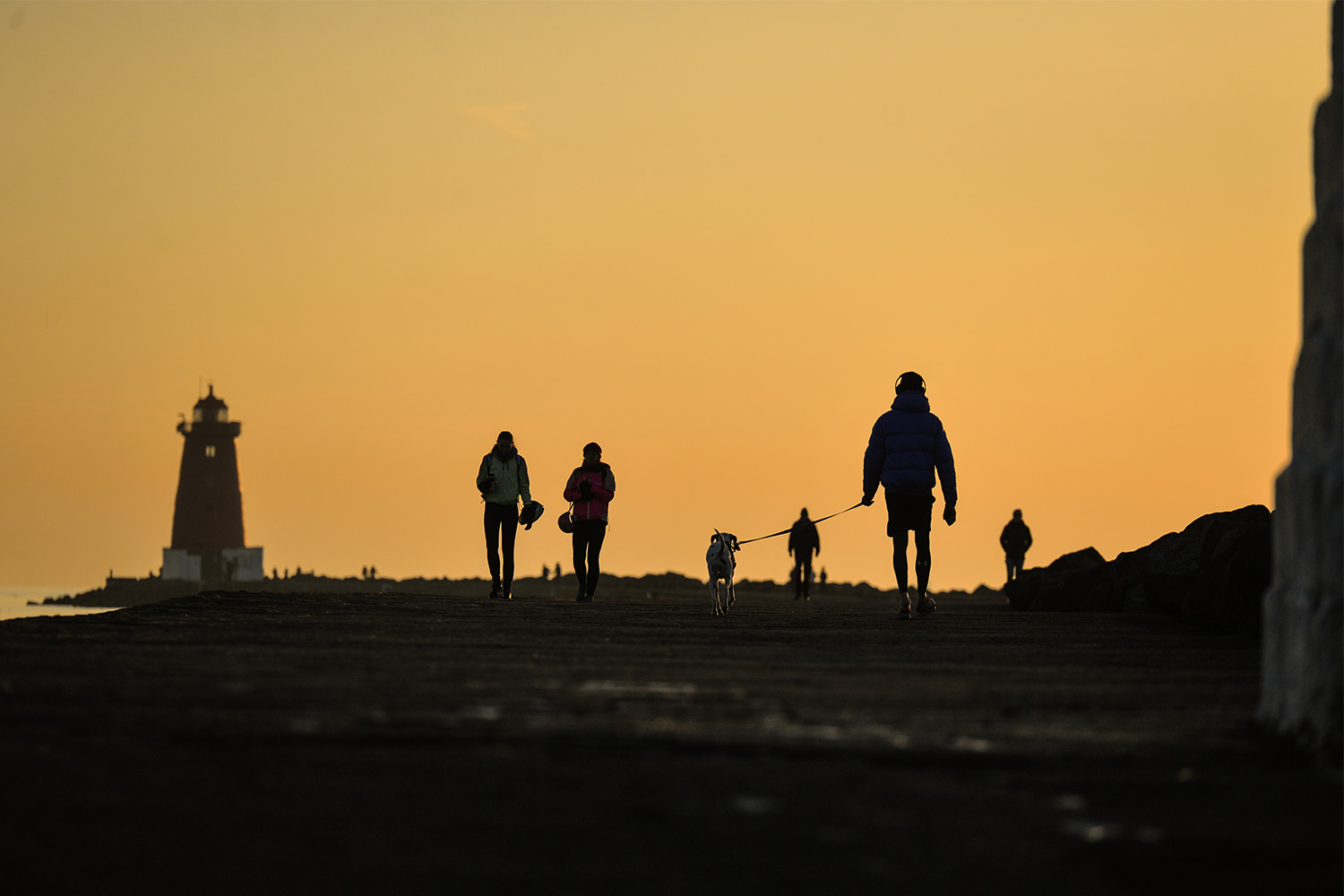 A smattering of exercisers on a dock at sunrise.