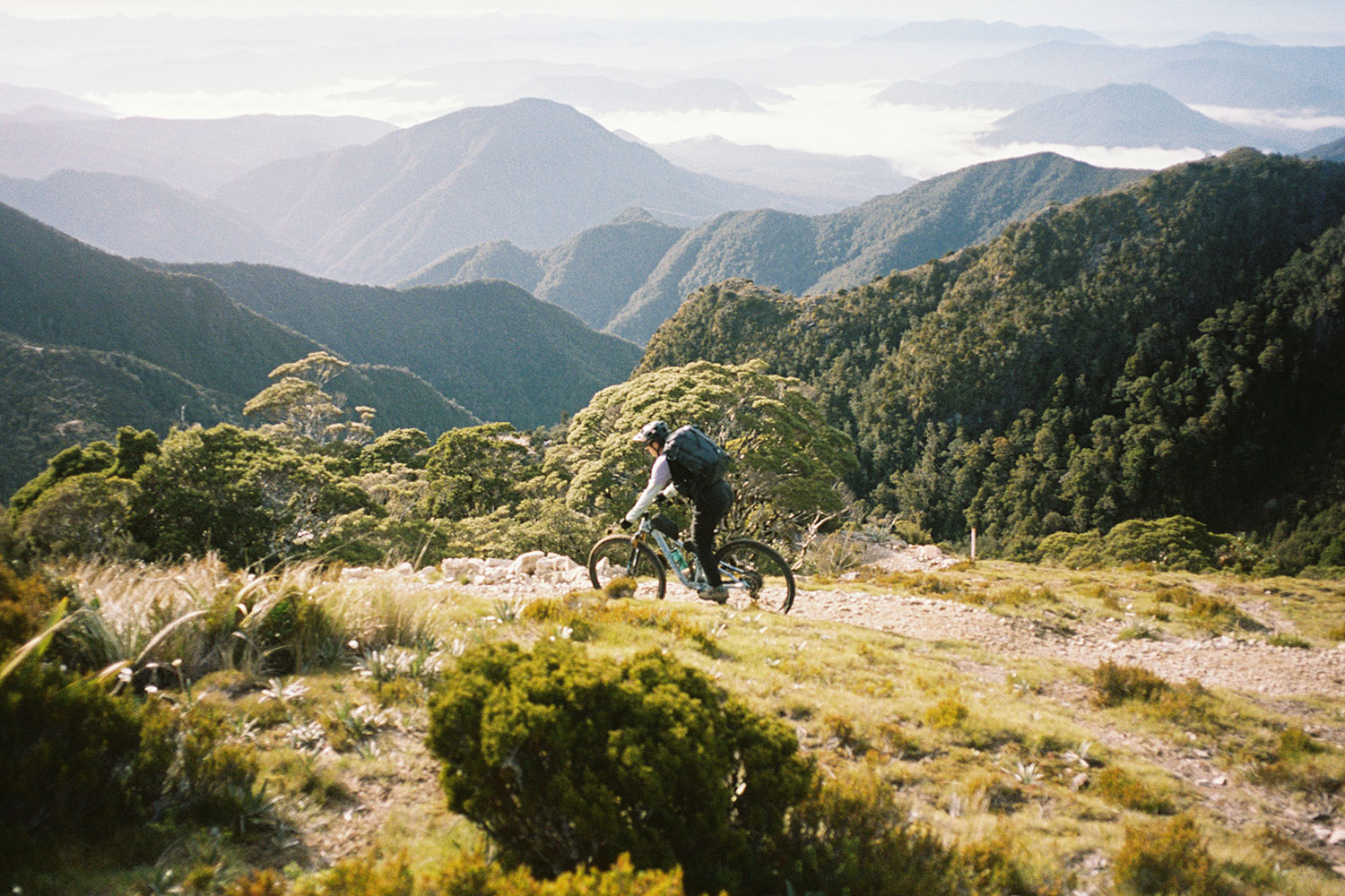 A cyclist in motion, with a dramatic mountain range in the background.