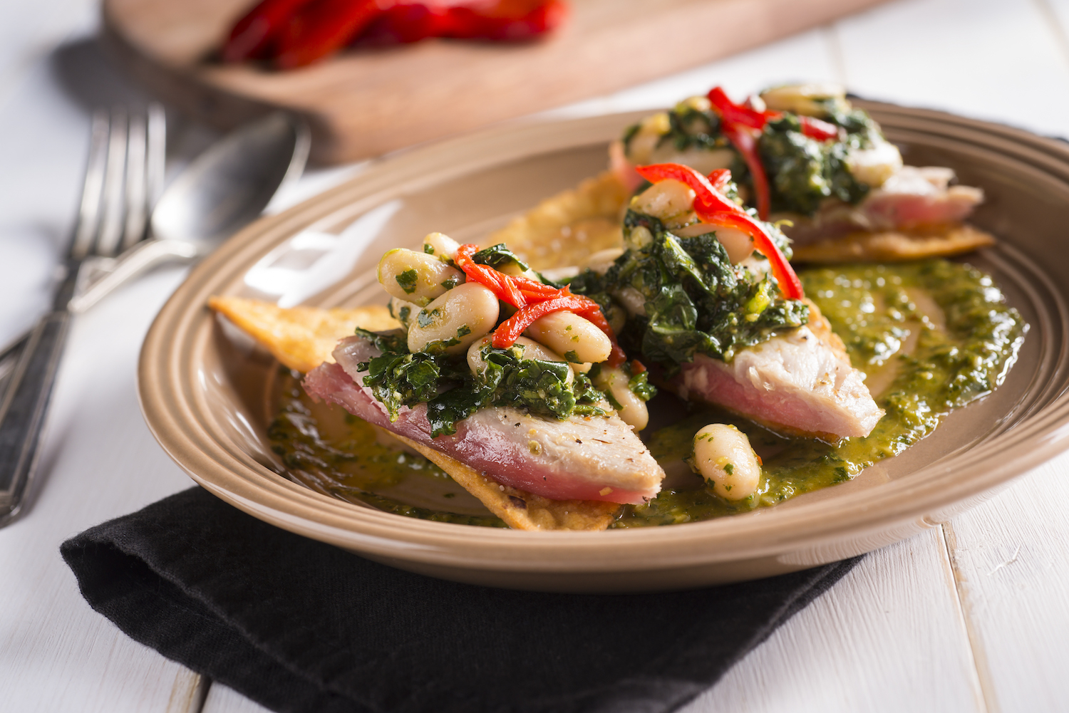 Tuna Tostada with Chimichurri on a tan plate