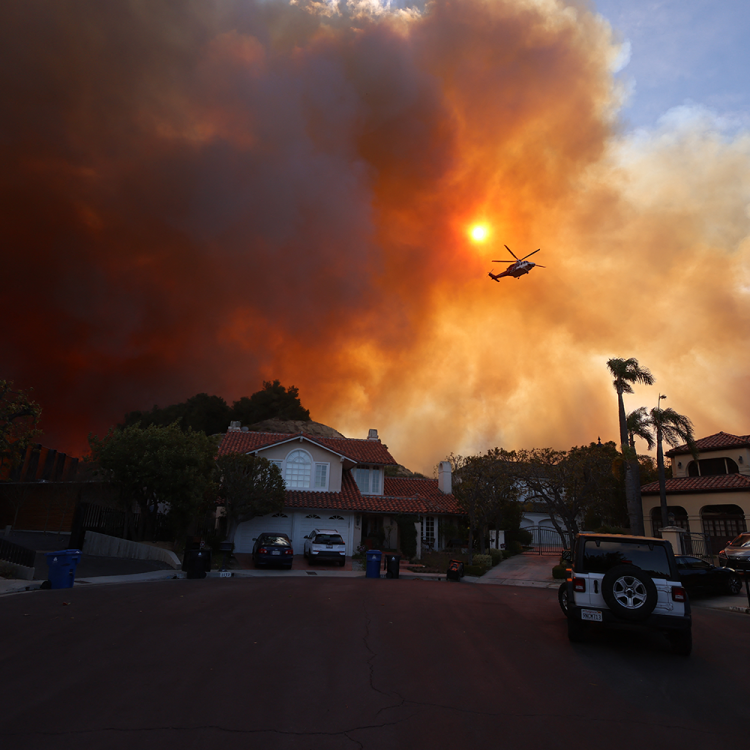 Plumes of smoke are seen as a brush fire burns in Pacific Palisades on Tuesday