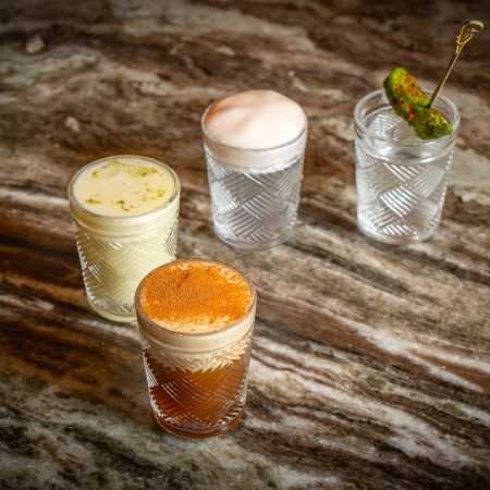 4 cocktail shots sitting on a wooden table